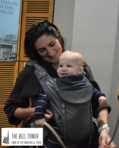 Mother helps her baby chime a bell