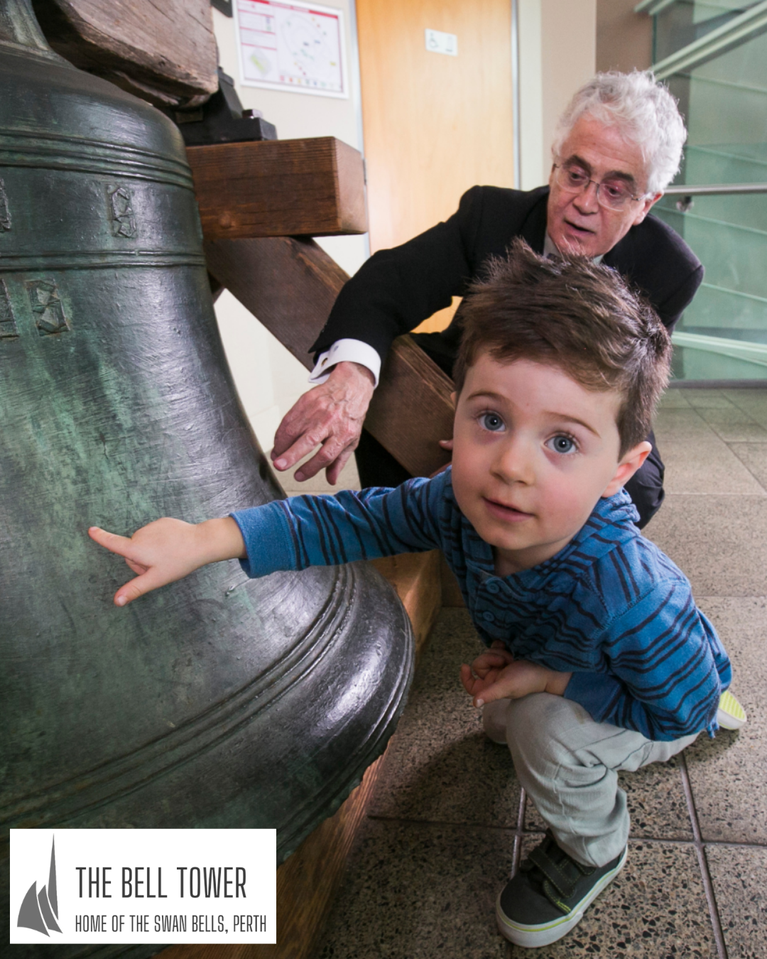 A young boy points at Australia's oldest boy, with his gradfather behind him.